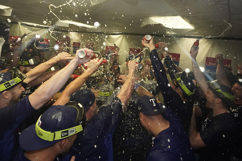 Texas Rangers players celebrate after beating the Tampa Bay Rays 7-1 during Game 2 in an AL wild-card baseball playoff series, Wednesday, Oct. 4, 2023, in St. Petersburg, Fla. (AP Photo/John Raoux)