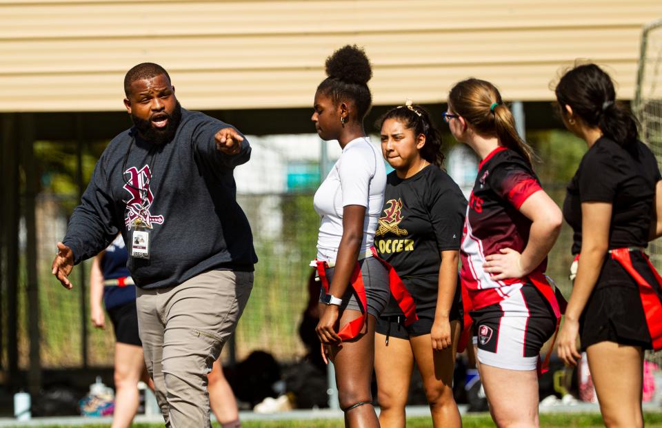 Kendoll Gibson, the coach of the girls flag football team at Riverdale High School talks with his players during a practice on Monday, Feb. 12, 2024. Gibson also coaches the boys team. This is the first year for flag football.