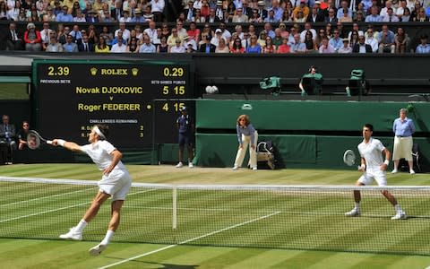 Switzerland's Roger Federer tries to reach out for the ball against Serbia's Novak Djokovic during their men's singles final match on day thirteen of the 2014 Wimbledon Championships at The All England Tennis Club in Wimbledon, southwest London, on July 6, 2014.  - Credit: AFP
