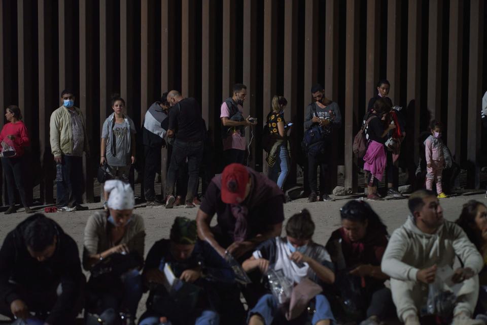 Migrants wait to be processed by US Border Patrol after illegally crossing the US-Mexico border in Yuma, Arizona in the early morning of July 11, 2022.  / Credit: ALLISON DINNER/AFP via Getty Images