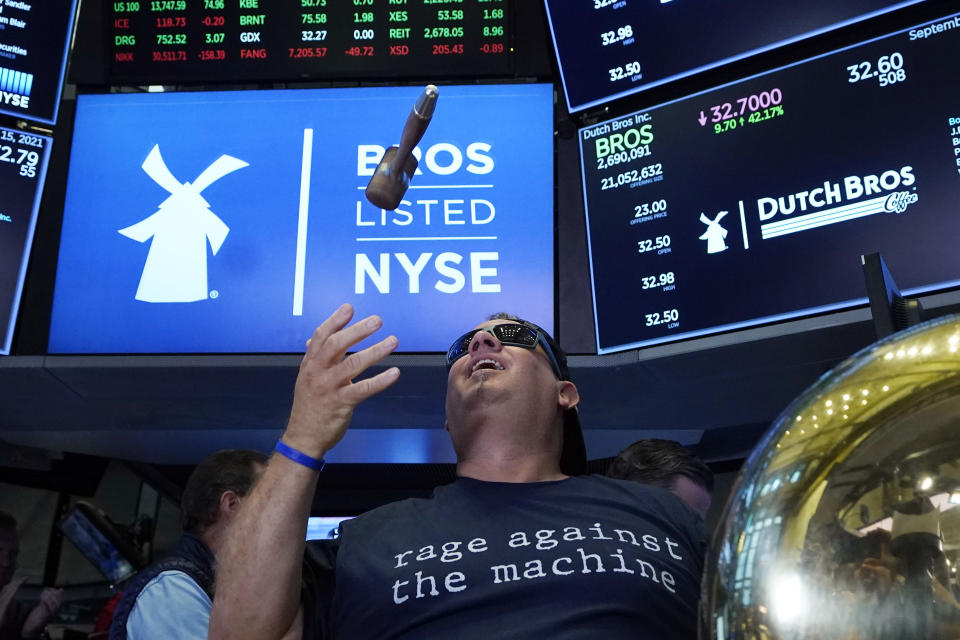 CORRECTS TITLE TO EXECUTIVE CHAIRMAN, NOT PRESIDENT - Dutch Bros Coffee Co-founder and Executive Chairman Travis Boersma tosses the gavel after he rang the ceremonial first trade bell on the floor of the New York Stock Exchange, as his company's IPO opens, Wednesday, Sept. 15, 2021. (AP Photo/Richard Drew)