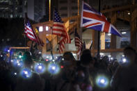 Protesters fresh their smartphone's lights near the British and American flags to give support the prayer rally at Edinburgh Place in Hong Kong, Saturday, Oct. 19, 2019. Hong Kong pro-democracy protesters are set for another weekend of civil disobedience as they prepare to hold an unauthorized protest march to press their demands. (AP Photo/Mark Schiefelbein)