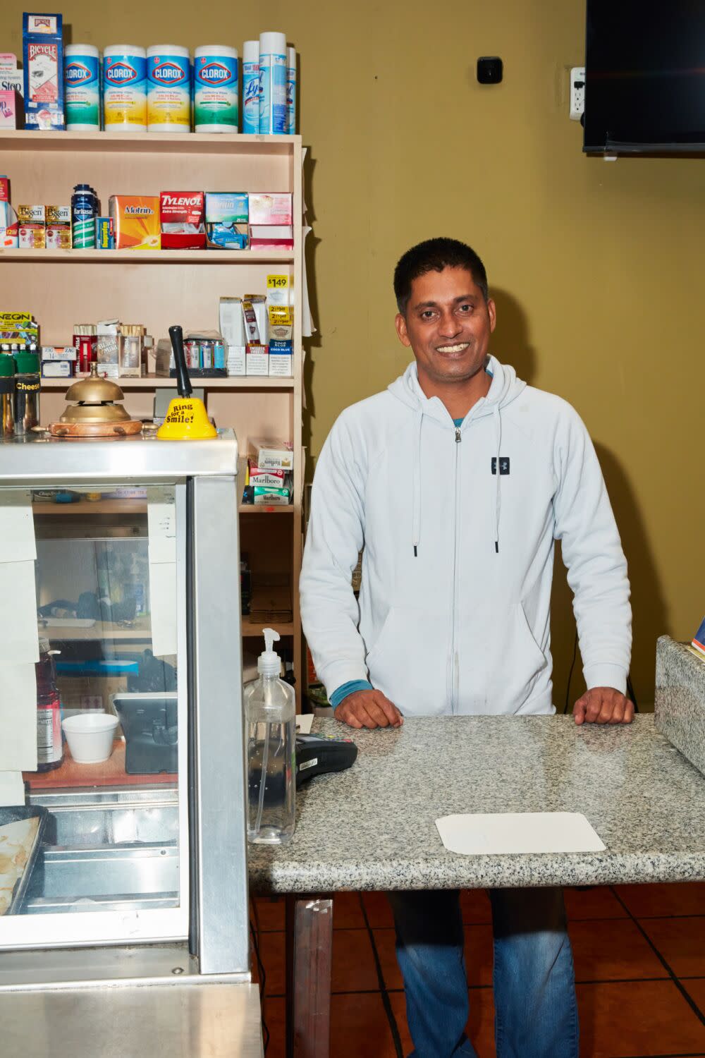 A man stands behind a restaurant counter.