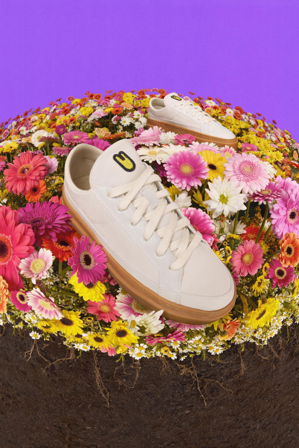 Unless Collective's plastic-free sneaker atop a bed of pink and yellow flowers. 