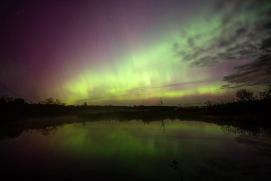 SMITHFIELD, MAINE – MAY 11, 2024: The northern lights dance in the sky as it reflects in the still water of North Pond in Smithfield, Maine on May 11, 2024. The aurora borealis, commonly referred to as the northern lights, are electrically charged particles that are interacting with gases in outer space. This recent display was the strongest seen since 2003 rating a G5 on the geomagnetic scale. (Photo by Michael Seamans/Getty Images)