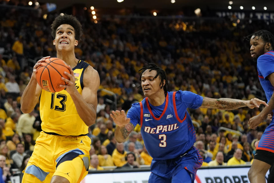 Marquette's Oso Ighodaro (13) shoots next to DePaul's Jalen Terry during the first half of an NCAA college basketball game Saturday, Feb. 25, 2023, in Milwaukee. (AP Photo/Aaron Gash)