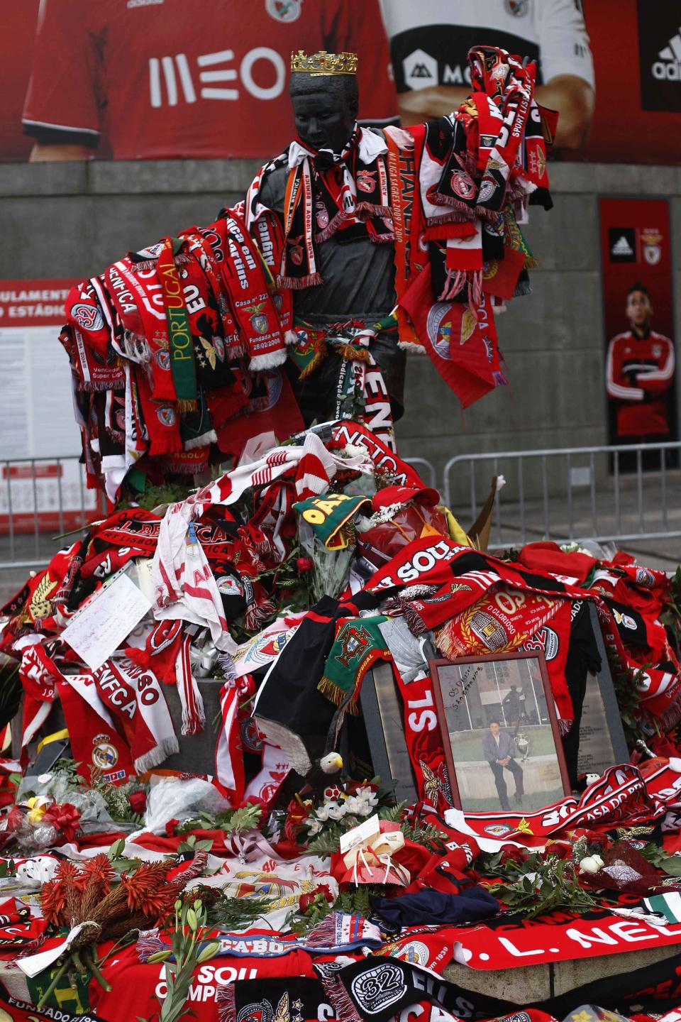 Eusebio monument at Luz stadium is covered by scarves and flowers in Lisbon January 6, 2014. Portuguese great Eusebio, top scorer at the 1966 World Cup, died on Sunday from a heart attack at the age of 71 with the small Iberian nation mourning him as an "eternal symbol" of their football pride.