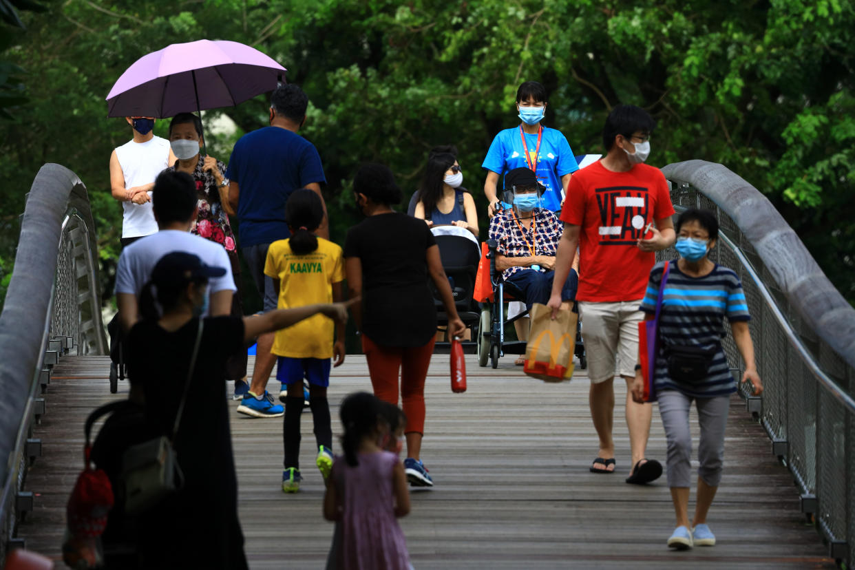 People wearing protective mask walk at a park on September 4, 2021 in Singapore. (Photo by Suhaimi Abdullah/NurPhoto via Getty Images)