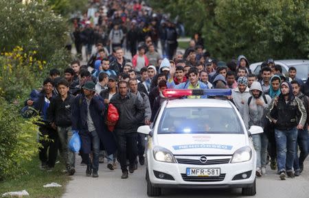 FILE PHOTO: Hungarian police lead migrants on their way to Austria, in Hegyeshalom, Hungary, September 27, 2015. REUTERS/Heinz-Peter Bader/File Photo