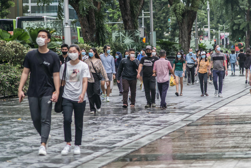 SINGAPORE - 2020/07/25: People wearing protective masks walk along Orchard Road, a famous shopping district in Singapore.  As of 26 July 2020, the total number of confirmed COVID-19 cases in Singapore are at 50,369. (Photo by Maverick Asio/SOPA Images/LightRocket via Getty Images)