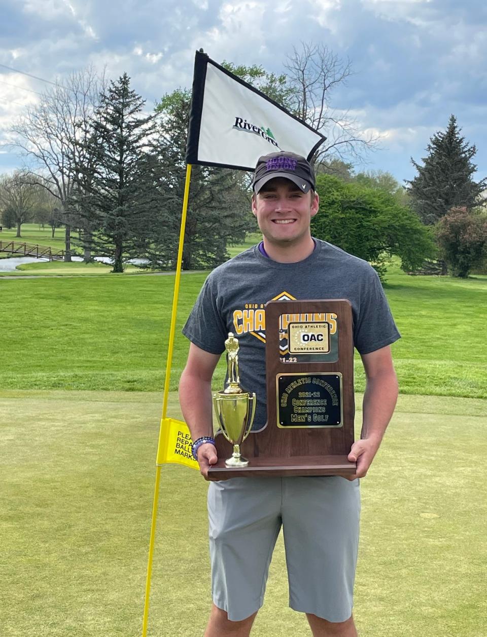 Mount Union junior Ian Smith, a Cambridge High graduate, holds the Ohio Athletic Conference Golf championship trophy after tying with John Carroll’s John Order for co-medalist honors at River Greens Golf Course earlier this month.