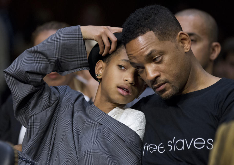 Actor Will Smith, and his daughter Willow Camille Reign Smith, accompanying Jada Pinkett Smith, not in picture, testifying in a Senate Foreign Relations Committee hearing about human trafficking, communicate in whisper, on Capitol Hill in Washington Tuesday, July 17, 2012. (AP Photo/Manuel Balce Ceneta)