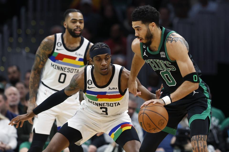 Minnesota Timberwolves' Jaden McDaniels (3) defends against Boston Celtics' Jayson Tatum, right, during the first half of an NBA basketball game, Friday, Dec. 23, 2022, in Boston. (AP Photo/Michael Dwyer)