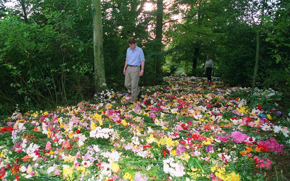 Earl Spencer walks through a carpet of flowers on the island where Princess Diana is buried