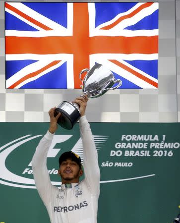 Formula One - F1 - Brazilian Grand Prix - Circuit of Interlagos, Sao Paulo, Brazil - 13/11/2016 - Mercedes' Lewis Hamilton of Britain raises his trophy during the victory ceremony after winning the race. REUTERS/Nacho Doce