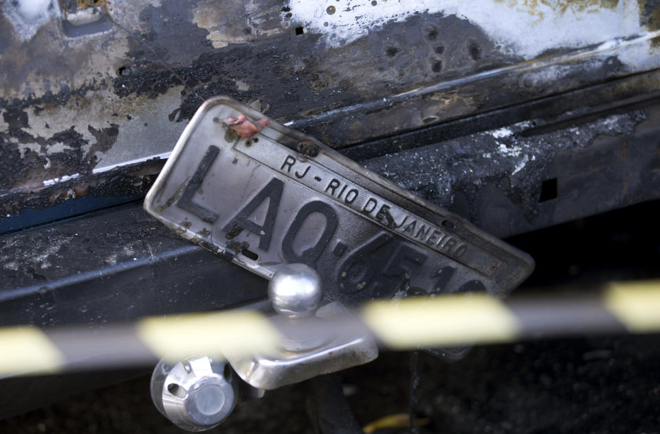 A charred car with Rio de Janeiro plates sits parked on the side of the street after protesters set several vehicles on fire to protest the death of an elderly woman who died yesterday during a police operation against suspected drug traffickers in the Complexo do Alemao in Rio de Janeiro, Brazil, Monday, April 28, 2014. The woman who died is Arlinda Bezerra das Chagas, age 72. (AP Photo/Silvia Izquierdo)