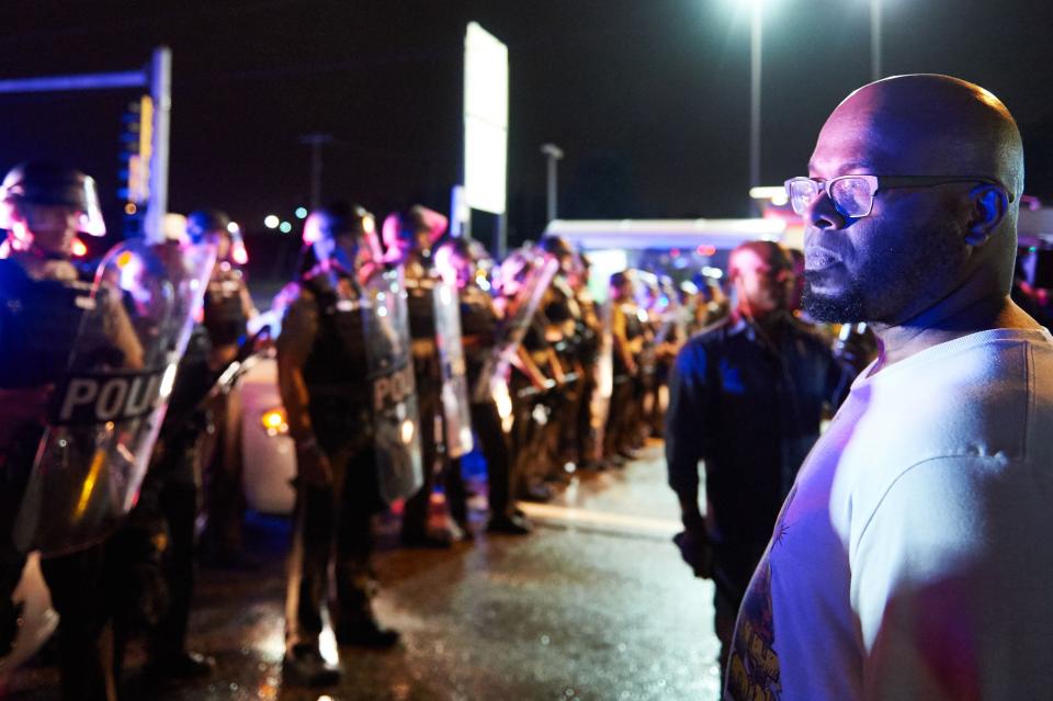 A demonstrator in front of police officers during a protest in Ferguson, Missouri, on Aug. 9, 2015.