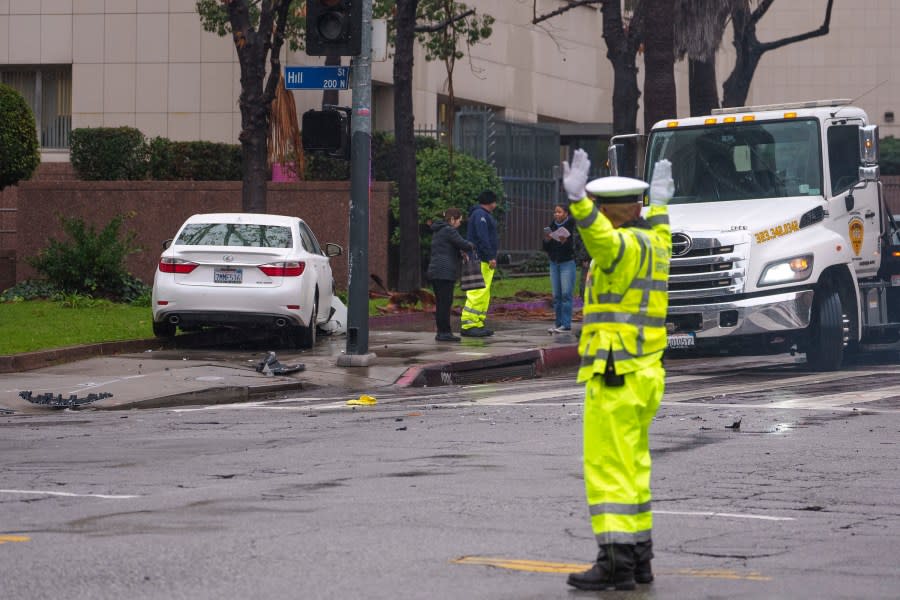 A traffic officer directs motorists after two were involved in a traffic collision at a busy intersection with nonworking traffic signals due to a power outage on Monday, Feb. 5, 2024, in Los Angeles. A storm of historic proportions has unleashed record levels of rain over parts of Los Angeles. The weather is endangering the city’s large homeless population, sending mud and boulders down hillsides dotted with multimillion-dollar homes and knocking out power for about 830,000 people in California. (AP Photo/Damian Dovarganes)