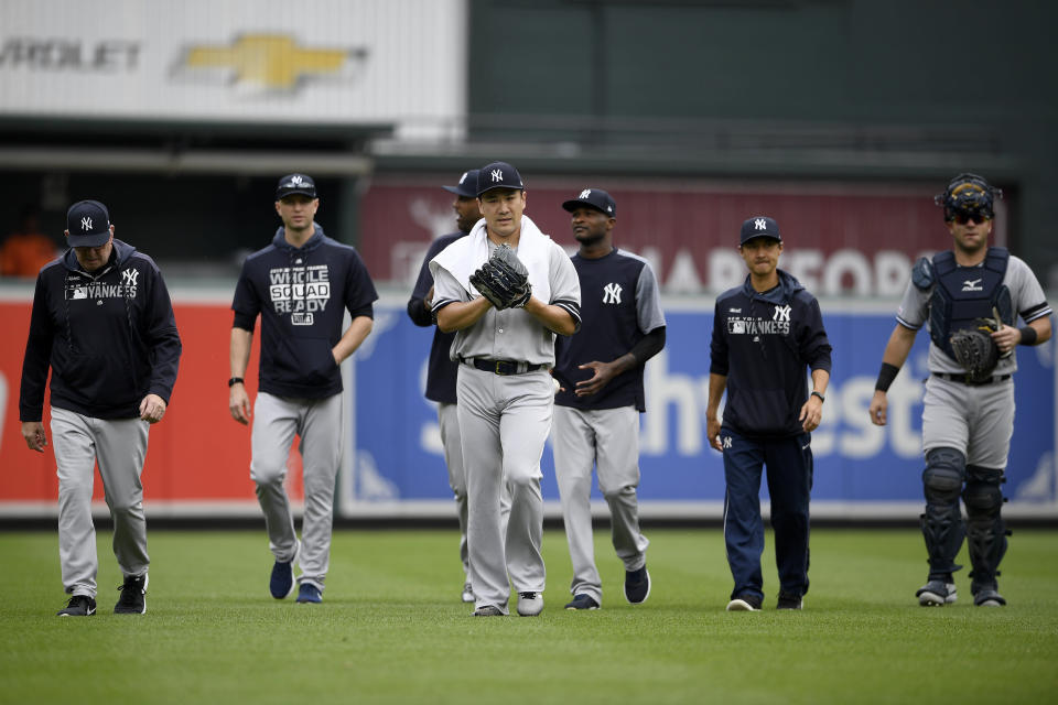 New York Yankees starting pitcher Masahiro Tanaka, of Japan, center front, walks in towards the dugout before a baseball game against the Baltimore Orioles, Thursday, May 23, 2019, in Baltimore. (AP Photo/Nick Wass)