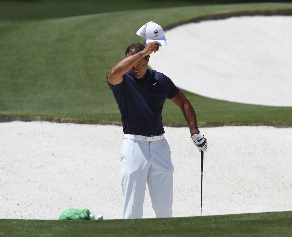 Tiger Woods pauses while getting in some work chipping at the practice range before his practice round for the Masters at Augusta National Golf Club in Augusta, Ga., Monday, April 4, 2022. (Curtis Compton /Atlanta Journal-Constitution via AP)