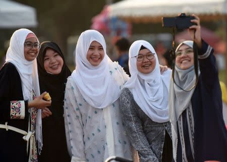 A group of women pose for a picture, before the start of Eid Al-Fitr prayers, which marks the end of the holy fasting month of Ramadan at Luneta Park in Metro Manila, Philippines June 25, 2017. REUTERS/Dondi Tawatao