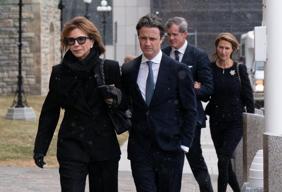 Mila Mulroney (left) walks with her son Nicolas, Caroline Mulroney and her husband Andrew Lapham as the family arrives on Parliament Hill, Monday, March 18, 2024 in Ottawa.