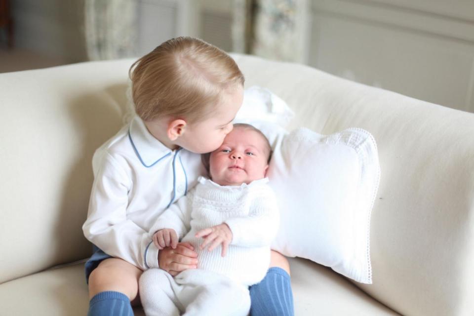 Prince George gives his two-week-old sister a loving kiss in this touching sibling portrait taken by the Duchess of Cambridge at their Norfolk home (PA)