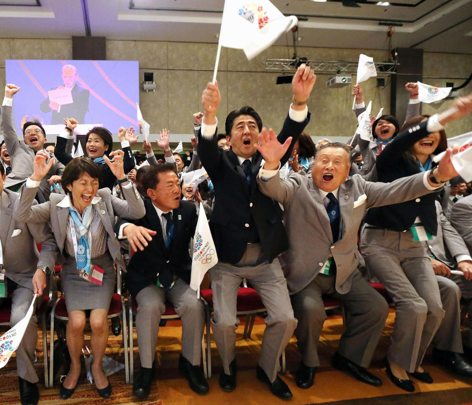 FILE - In this Sept. 7, 2013, file photo, Japanese Prime Minister Shinzo Abe, center, and former prime minister Yoshiro Mori, right, with other delegates, celebrate after Tokyo was awarded the 2020 Summer Olympic Games, in Buenos Aires, Argentine. Abe was in the front row in 2013 in Buenos Aires when IOC President Jacques Rogge opened an envelop to show Tokyo was the 2020 host, beating out Istanbul. (Kyodo News via AP, File)