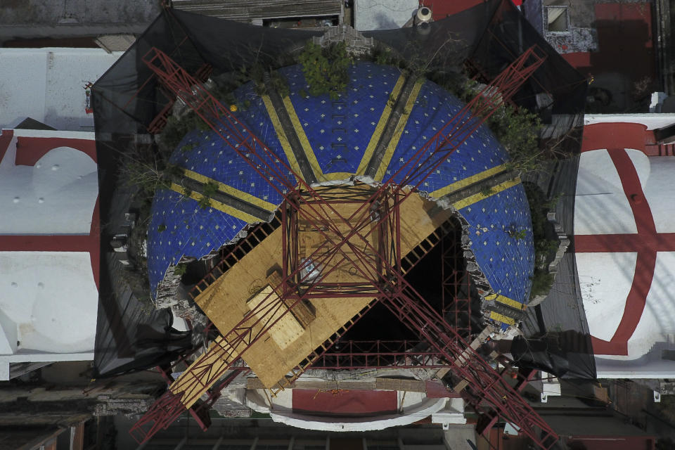 A steel framework providing a platform for workers and supports for a planned roof encases the damaged church cupola, during the early stages of reconstruction work at Nuestra Senora de Los Angeles, or Our Lady of Angels church, three years after an earthquake collapsed nearly half of its 18th-century dome in Mexico City, Friday, Oct. 16, 2020. It is so dangerous to stand beneath the remains of the dome that the tons of steel structures are made off-site and then gingerly lowered into the crater at the center where the dome once stood. (AP Photo/Rebecca Blackwell)