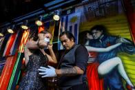 FILE PHOTO: Makrina Anastasiadou puts on a face mask before dancing with her tango partner "El Morocho" after tango shows have been suspended to prevent the spread of coronavirus (COVID-19), in Buenos Aires