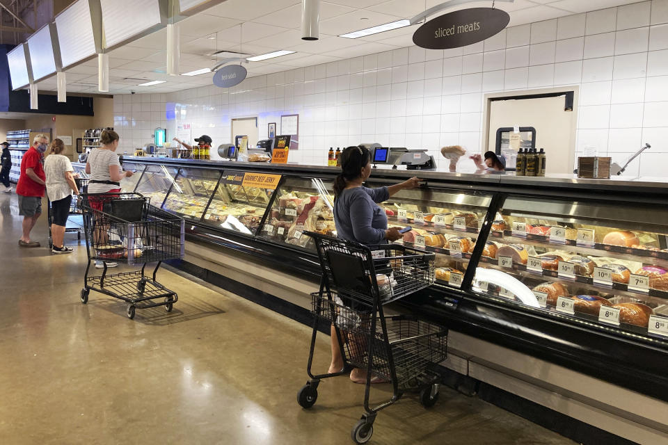 Shoppers shop at a grocery store in Glenview, Ill., Monday, July 4, 2022. U.S. demand for grocery delivery is cooling as food prices rise. Some shoppers are shifting to less expensive grocery pickup, while others are returning to the store. (AP Photo/Nam Y. Huh)