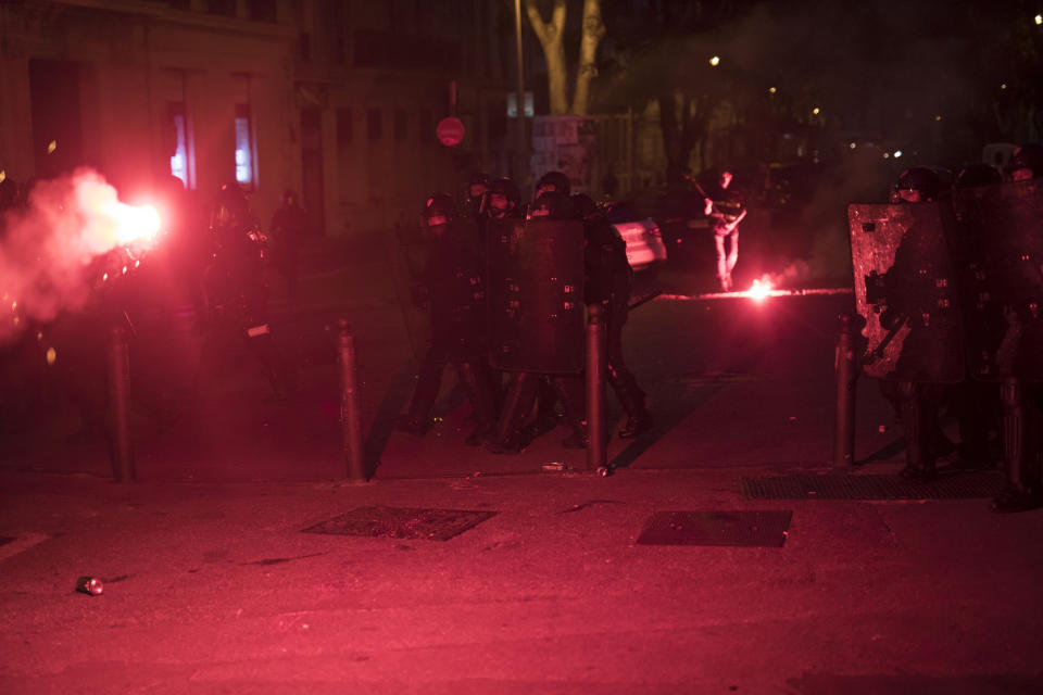 Police react to fireworks launched at them by protesters in Marseille, southern France, Saturday, June 6, 2020. Protesters marched against the death of George Floyd, who died after he was restrained by police officers May 25 in Minneapolis, that has led to global protests. Further demonstrations are planned over the weekend in European cities, some defying restrictions imposed by authorities due to the coronavirus pandemic. (AP Photo/Daniel Cole)