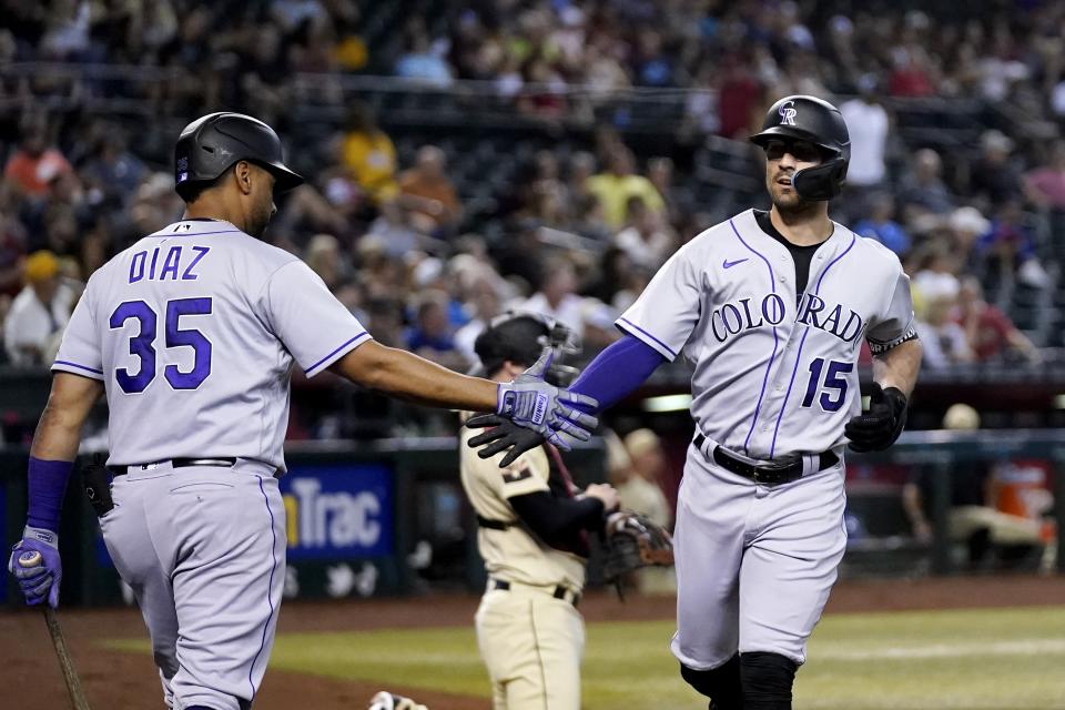 Colorado Rockies' Randal Grichuk (15) celebrates with Elias Diaz (35) after his home run against the Arizona Diamondbacks during the first inning of a baseball game Friday, Aug. 5, 2022, in Phoenix. (AP Photo/Ross D. Franklin)