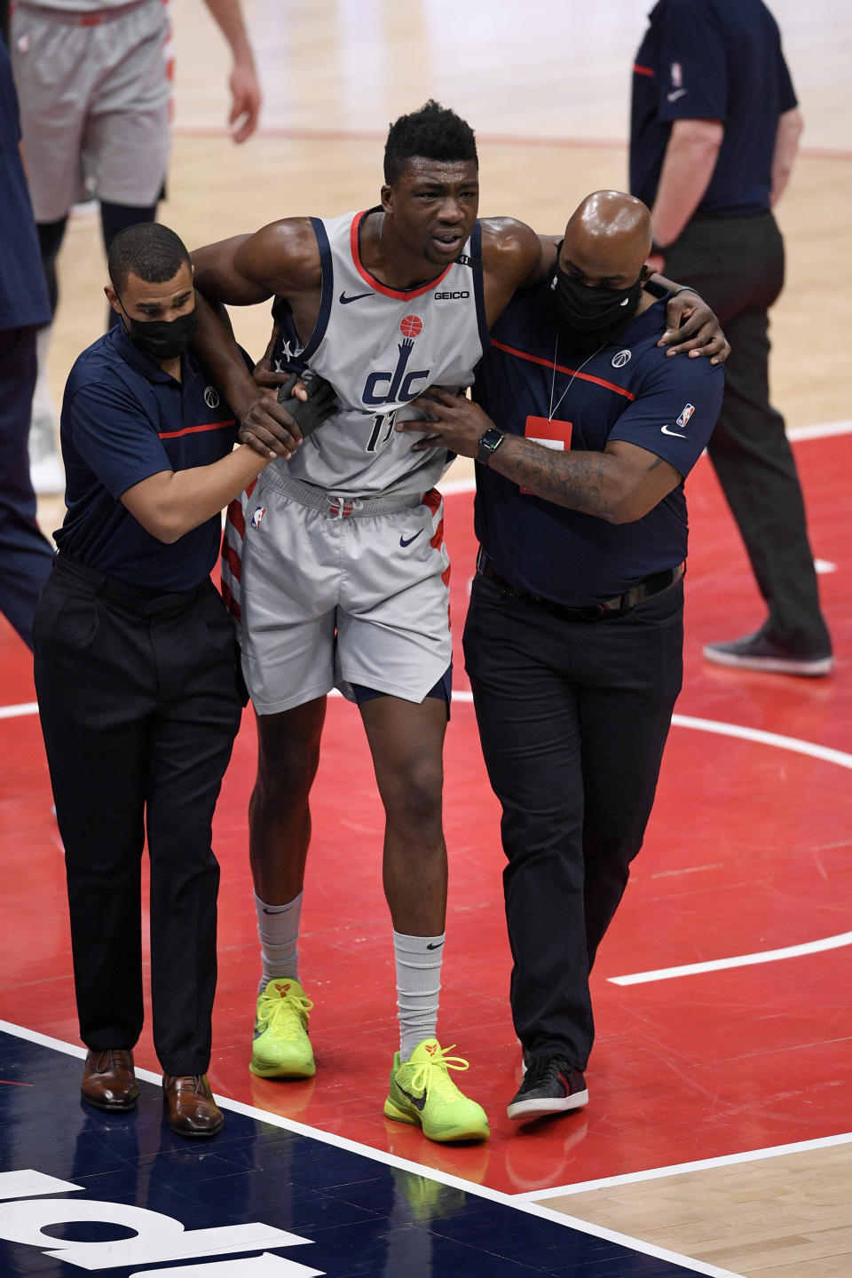 Washington Wizards center Thomas Bryant (13) is helped off the court after he was injured during the first half of an NBA basketball game against the Miami Heat, Saturday, Jan. 9, 2021, in Washington. (AP Photo/Nick Wass)