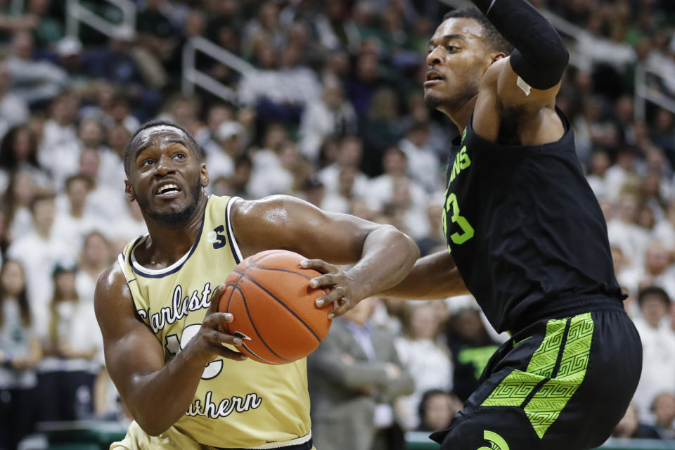 Charleston Southern forward Ty Jones, left, is defended by Michigan State forward Xavier Tillman (23) during the first half of an NCAA college basketball game, Monday, Nov. 18, 2019, in East Lansing, Mich. (AP Photo/Carlos Osorio)