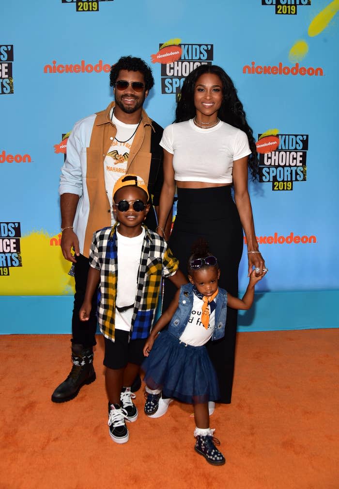 Ciara, Russell, and two of their children on the orange carpet of the Nickalodeon Kids' Choice Awards