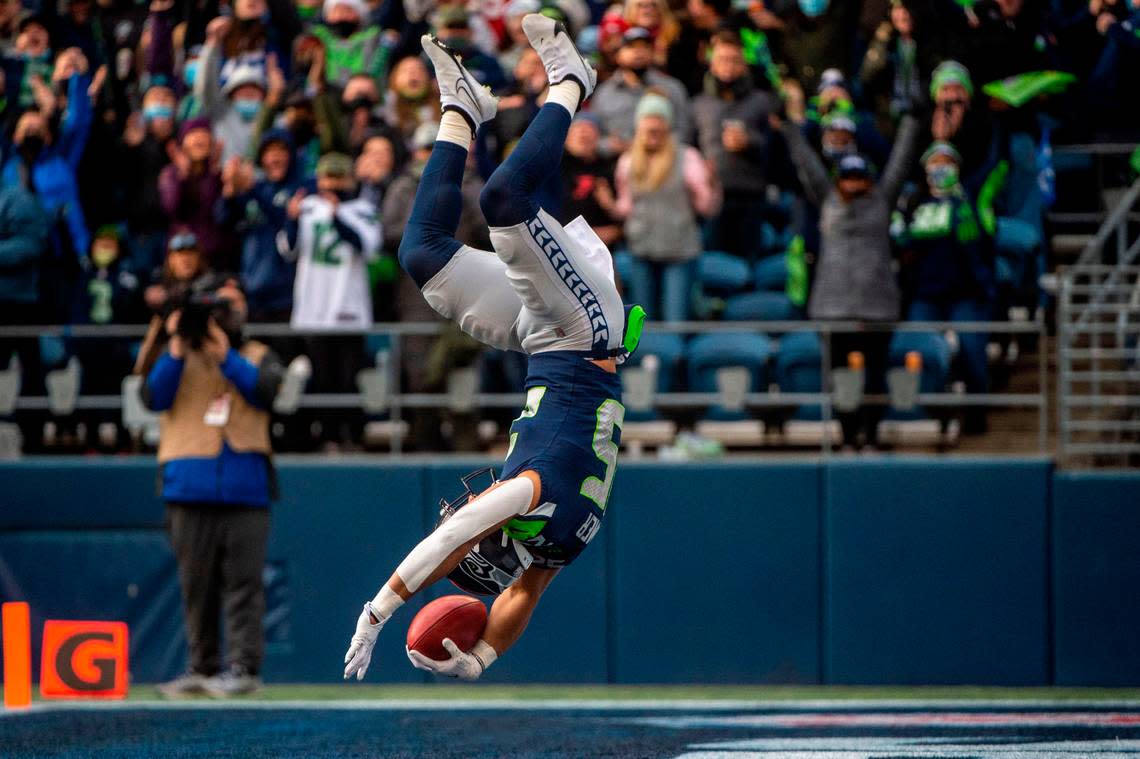 Seattle Seahawks running back Travis Homer (25) flips into the endzone after running a fake punt in for a touchdown in the first quarter of an NFL game against the San Francisco 49ers on Sunday at Lumen Field in Seattle.