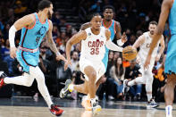 Cleveland Cavaliers' Isaac Okoro (35) starts a fast break against the Phoenix Suns' Duane Washington Jr. (4) and Deandre Ayton, right, during the first half of an NBA basketball game in Phoenix, Sunday, Jan. 8, 2023. (AP Photo/Darryl Webb)