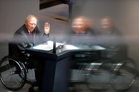 German Finance Minister Wolfgang Schaeuble is reflected in a window as he gives a speech for a budget debate at the German national parliament in Berlin, Germany September 8, 2015. REUTERS/Fabrizio Bensch/Files