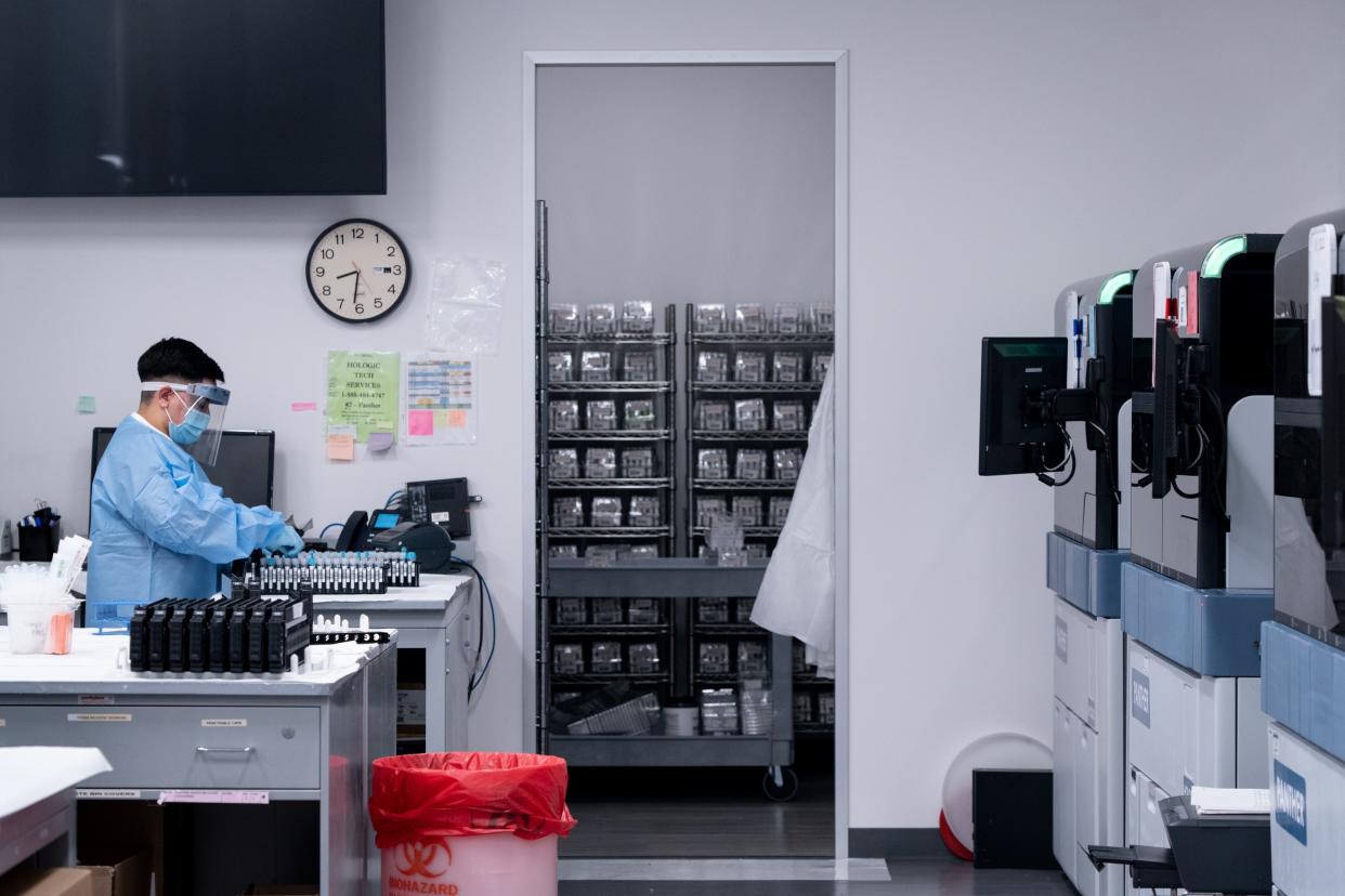 Jeniffer Gutierrez runs COVID-19 tests in the lab on Jan. 11, 2022, at Sonora Quest Laboratories in Phoenix.