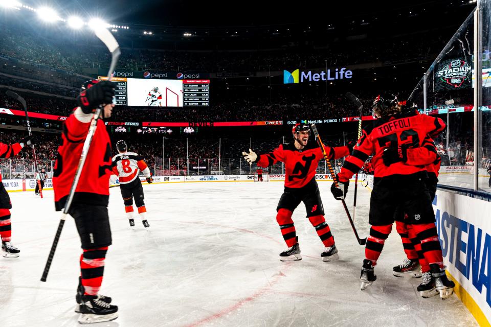 New Jersey Devils players celebrate after Tyler Toffoli, front right, scored against the Philadelphia Flyers in the first period of an NHL Stadium Series game in East Rutherford, N.J., Saturday, Feb. 17, 2024. (AP Photo/Peter K. Afriyie)
