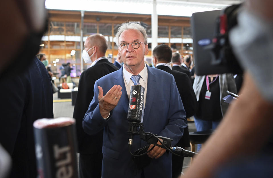 Saxony-Anhalt state governor Reiner Haseloff, center, of Merkel's Christian Democratic Union party, CDU, speaks to media after the first exit polls of the state elections announced in Magdeburg, Germany, Sunday, June 6, 2021 . The election for the new state parliament in Saxony-Anhalt was the last state election before the federal election in September 2021. (Bernd Von Jutrczenka/dpa via AP)