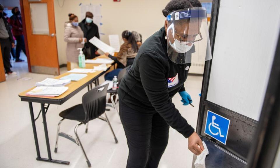 Election day poll worker Darline Harris sanitizes a voting booth between voters at a polling location at the Morning Star Baptist church in Boston, Massachusetts.