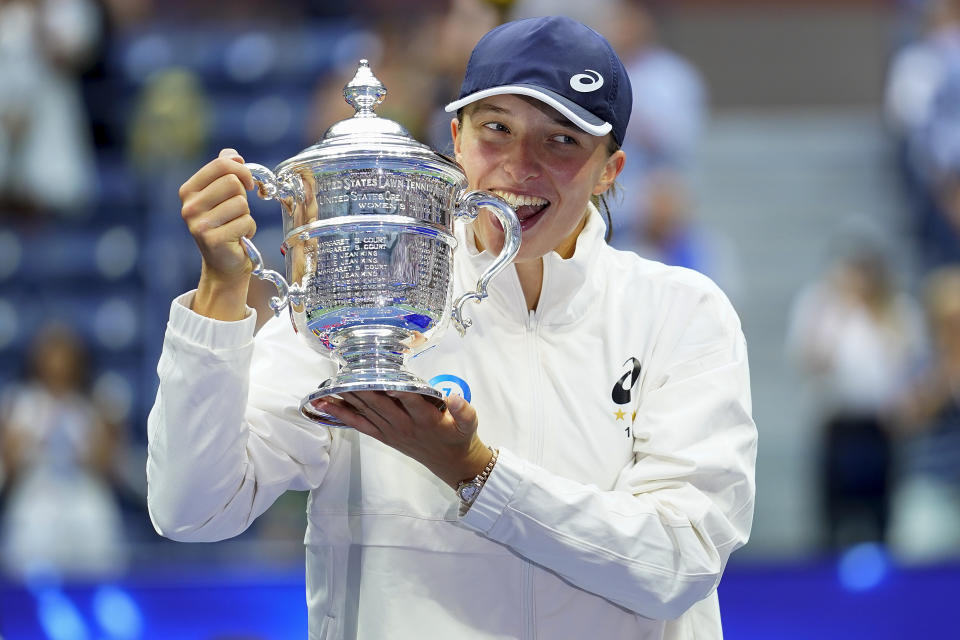 Iga Swiatek, of Poland, poses for a photo with the championship trophy after defeating Ons Jabeur, of Tunisia, in the women's singles final of the U.S. Open tennis championships, Saturday, Sept. 10, 2022, in New York. (AP Photo/Matt Rourke)