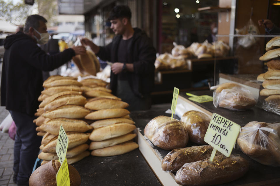 FILE - A man buys bread in Ulus district of the capital Ankara, Turkey, Thursday, May 5, 2022. Some 1.6 billion people in 94 countries face at least one dimension of the crisis in food, energy and financial systems, according to a report last month by the Global Crisis Response Group of the United Nations Secretary-General. (AP Photo/Burhan Ozbilici, File)