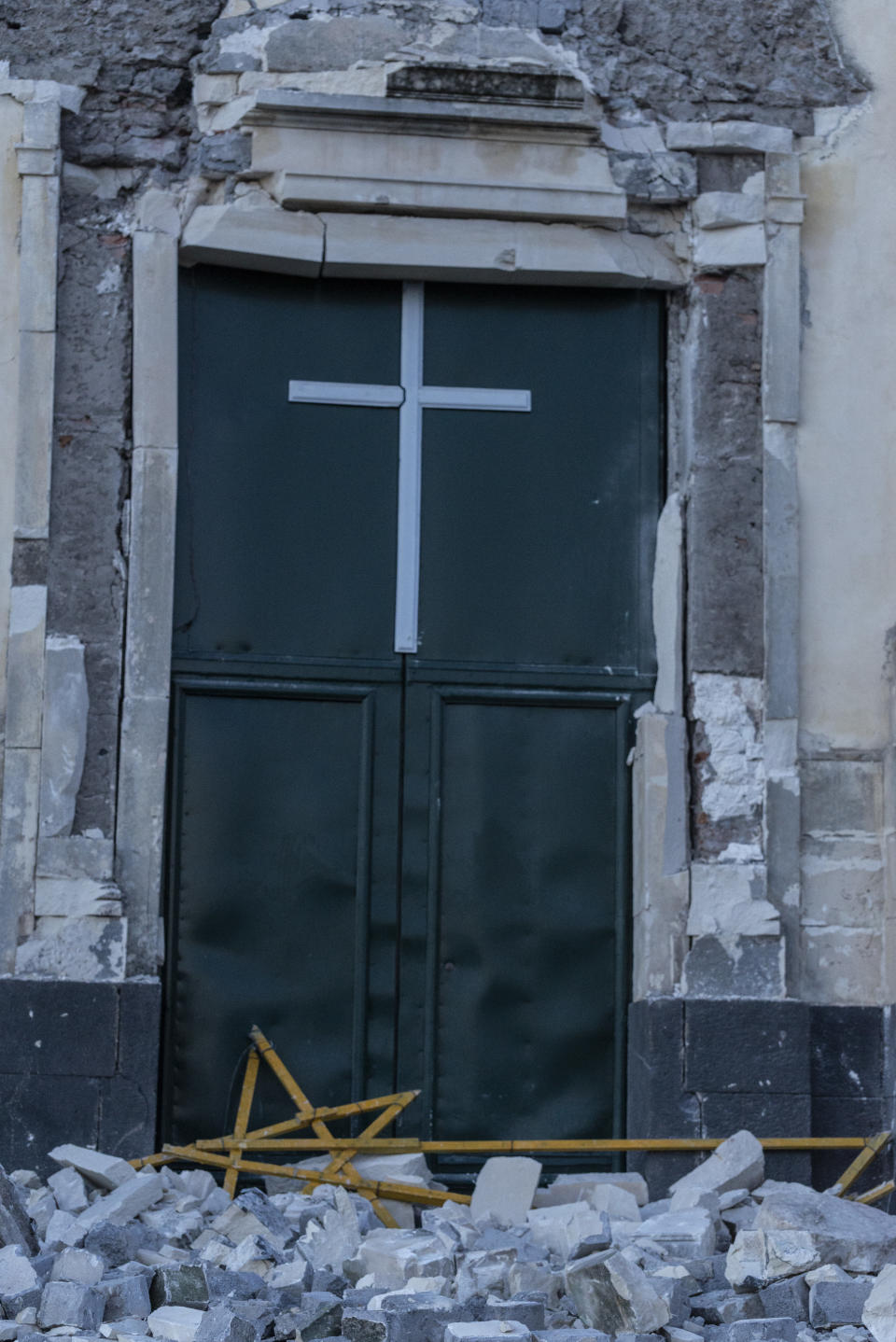 Debris stand in front of the heavily damaged church of Maria Santissima in Fleri, Sicily Italy, Wednesday, Dec. 26, 2018. A quake triggered by Italy's Mount Etna volcano has jolted eastern Sicily, slightly injuring 10 people and prompting frightened Italian villagers to flee their homes. (AP Photo/Salvatore Allegra)