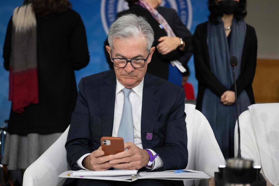 Претседателот на Федералните резерви Џером Пауел гледа во својот телефон за време на состанокот на Меѓународниот монетарен и финансиски комитет на Годишните состаноци на Групацијата на Меѓународниот монетарен фонд на Светска банка во Вашингтон, ДЦ, на 14 октомври 2022 година. (Фото: Џим ВОТСОН / АФП) (Фото од ЏИМ ВОТСОН/АФП преку Гети Имиџис)