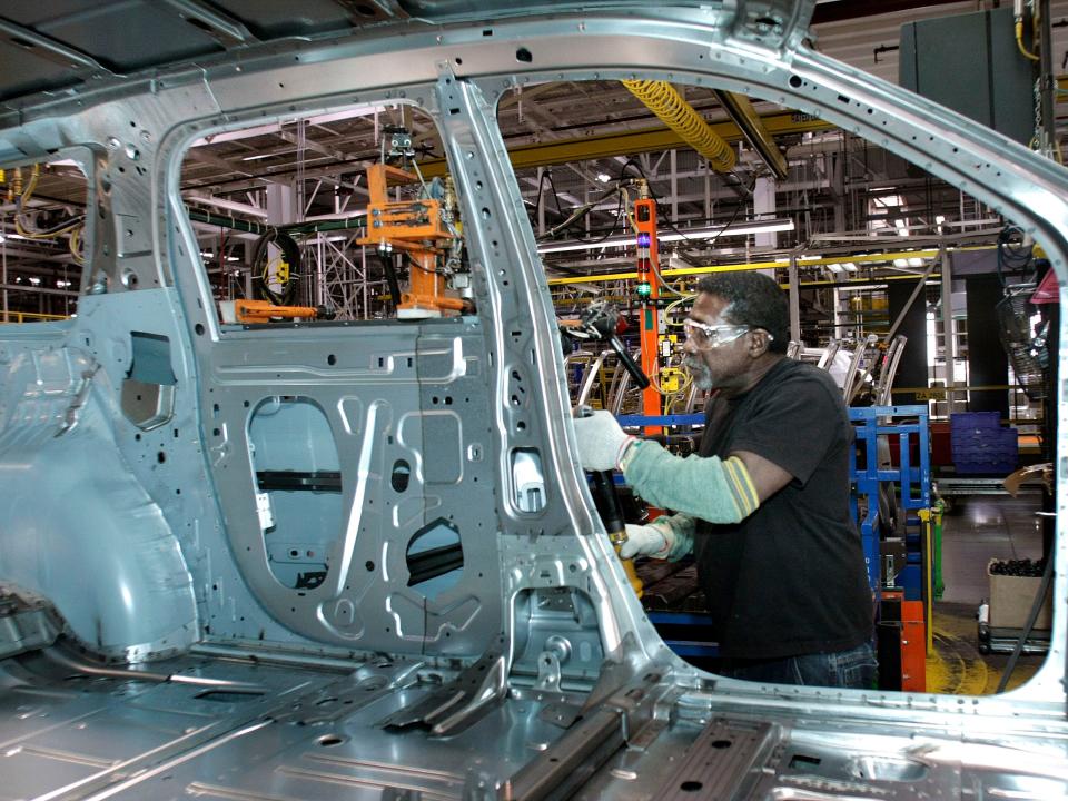 person working on a car at a michigan gm plant