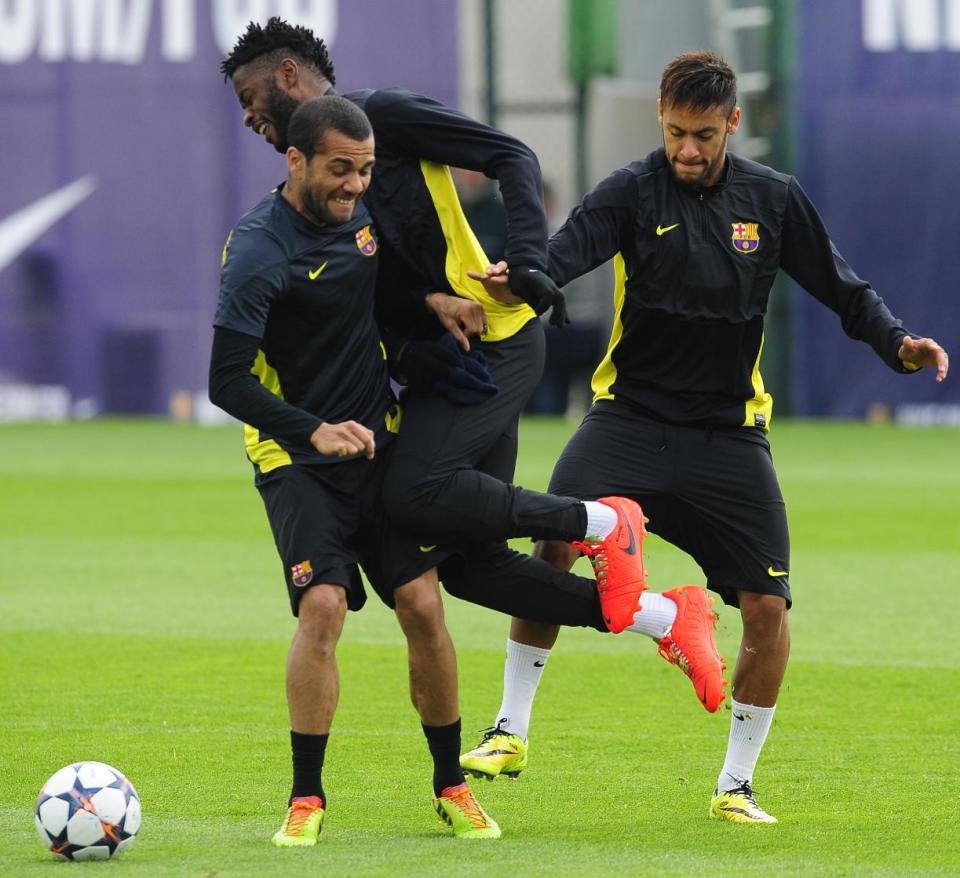 FC Barcelona's Neymar, from Brazil, right, Daniel Alves, from Brazil, second left, and Alex Song attend a a training session at the Sports Center FC Barcelona Joan Gamper in San Joan Despi, Spain, Monday, March 31, 2014. FC Barcelona will face Atletico Madrid in a first leg quarter-final Champions League soccer match on April 1. (AP Photo/Manu Fernandez)