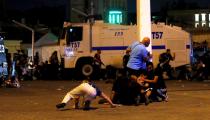 FILE PHOTO: People take cover near policemen as gunfire are heard during an attempted coup in Istanbul's Taksim Square